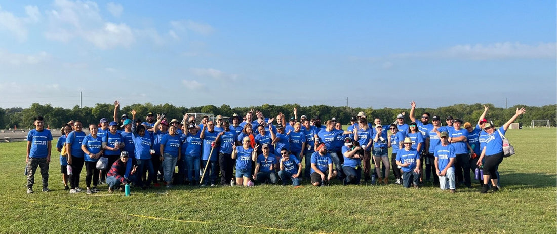 adults volunteering at a local non-profit organization. This organization benefits adults with cognitive and behavioral disabilities. They are standing on a soccer field.